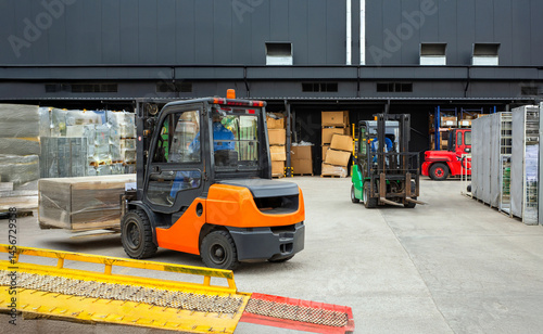 A forklift is driving down a ramp with a yellow and red barrier