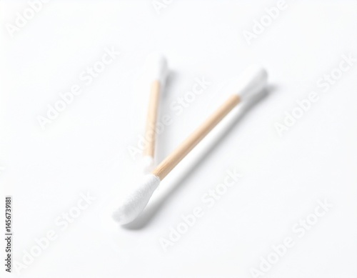Obraz na płótnie Two cotton swabs lie angled on a white surface. The swabs have fluffy cotton ends and tan sticks. They seem clean w salonie