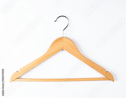 Obraz na płótnie A single, wooden clothes hanger with a chrome hook hangs against a bright, clean white background. It looks unused and ready for use w salonie