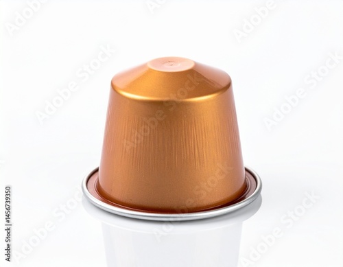 Obraz na płótnie A close-up shot showcases a metallic copper-colored coffee capsule. It's perched on a reflective silver rim, set against a bright white backdrop w salonie