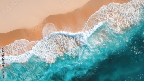 Obraz na płótnie Aerial view of turquoise ocean waves crashing onto a golden sandy beach. w salonie