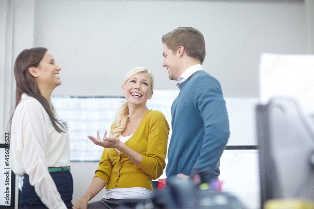 Fototapeta premium Relax, business people and laugh in office for discussion, conversation and good news on startup project. Creative agency, women and man with happiness for teamwork, announcement or break with comedy