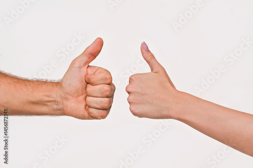 A man's and a woman's hand shows a class gesture. thumb up on a white background.