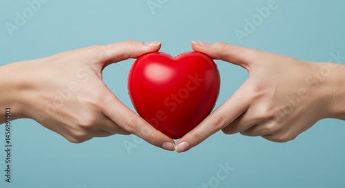 Hands Gently Holding Red Heart Shape Against Light Blue Background Symbolizing Love and Care