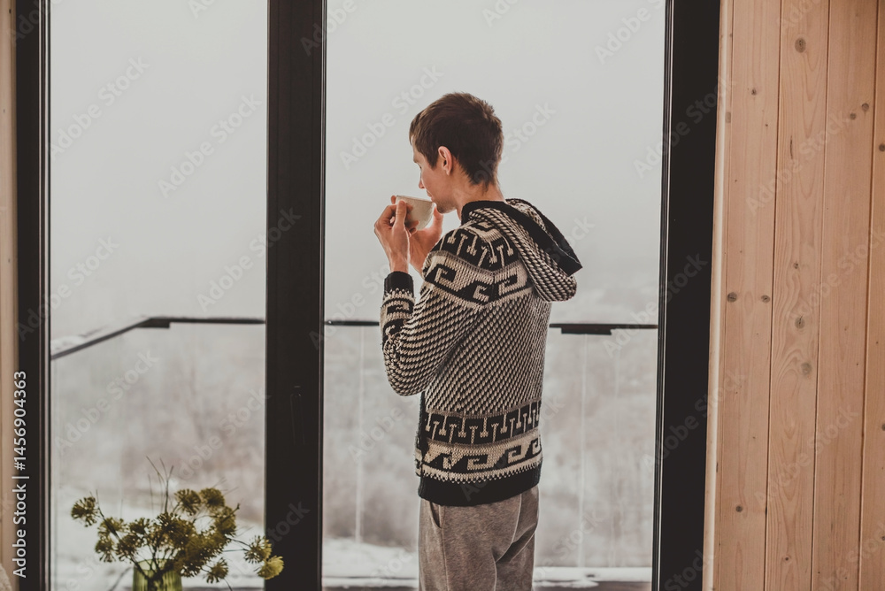 Man Drinking Morning Coffee in Log Cabin