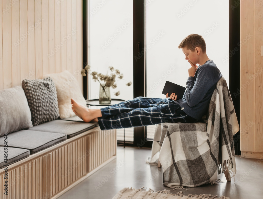 Teen Boy Reading Book in Cozy Log Cabin