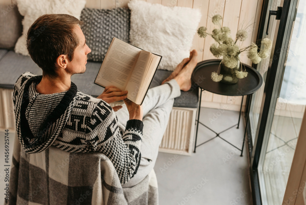 Man Reading Book in Cozy Log Cabin