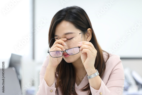 업무 중 눈의 피로를 느끼는 안경 쓴 여성