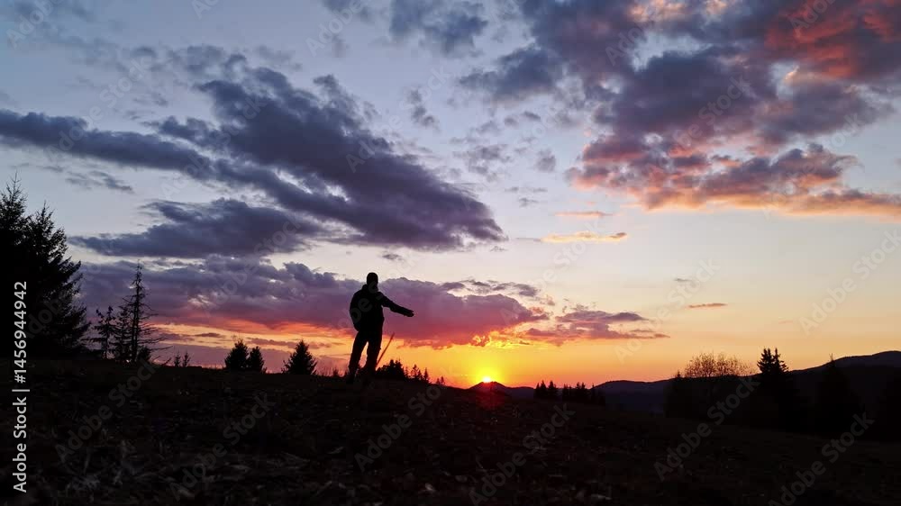 Slow motion silhouette of a person waving hand against the sunset Slow motion silhouette of a person waving hand against the sunset
