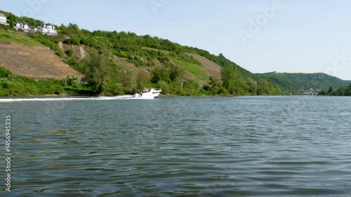 Winningen, Germany - May 02, 2025: Nautical vessel on River Mosel nearby Winningen, Rhineland-Palatinate, Germany. The Moselle is a river that rises in the Vosges mountains and flows through north-eas