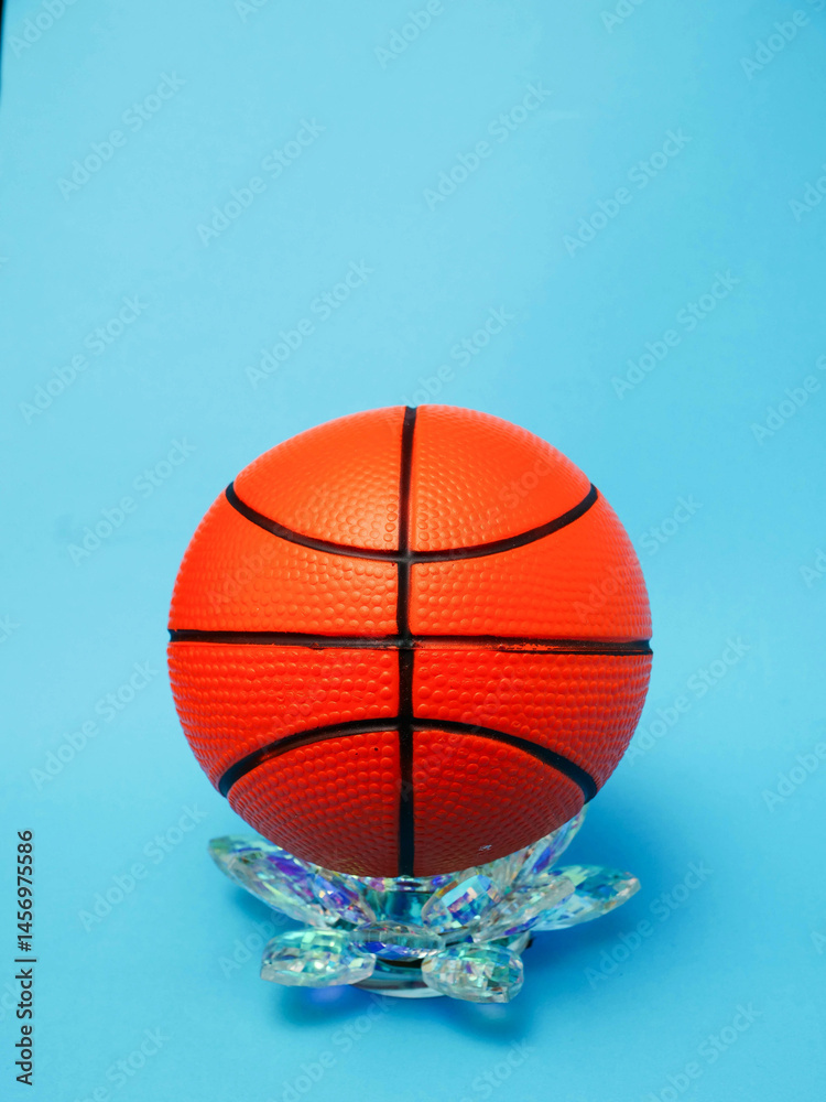 Classic basketball is on a glass fixture. Blue color background. Popular team game. Sport equipment.