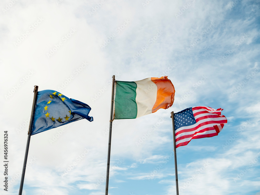 Flags or Euro Union, Ireland and USA blue cloudy sky background.. Friendship and social and economical relationship concept.