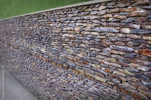 wall lined with oblong natural stone of various shades, landscape design