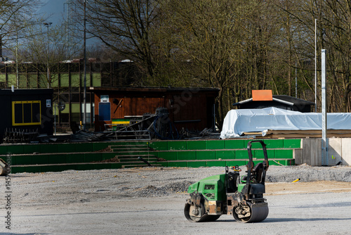 Construction site featuring a compactor on a gravel surface