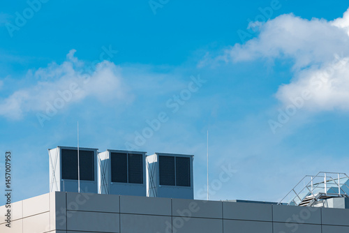 Rooftop cooling units under clear blue sky on sunny day