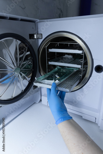 A Technician in Blue Gloves Is Operating a Laboratory Freeze Dryer, Extracting Items from the Chamber to Preserve Various Samples for Research and Experimental Purposes