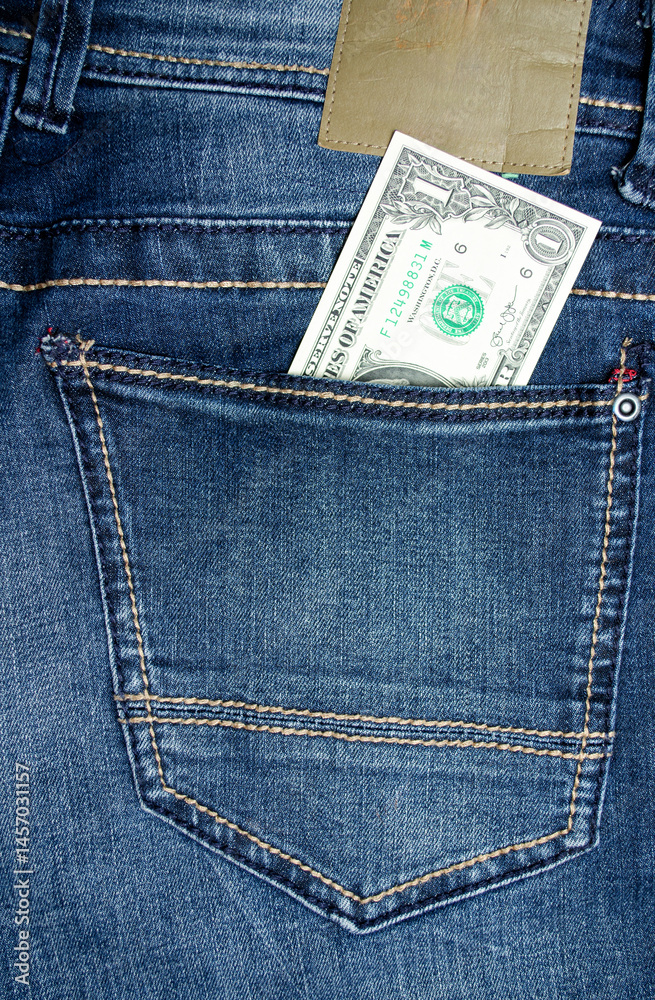 1 dollar lies in the pocket of blue jeans close-up