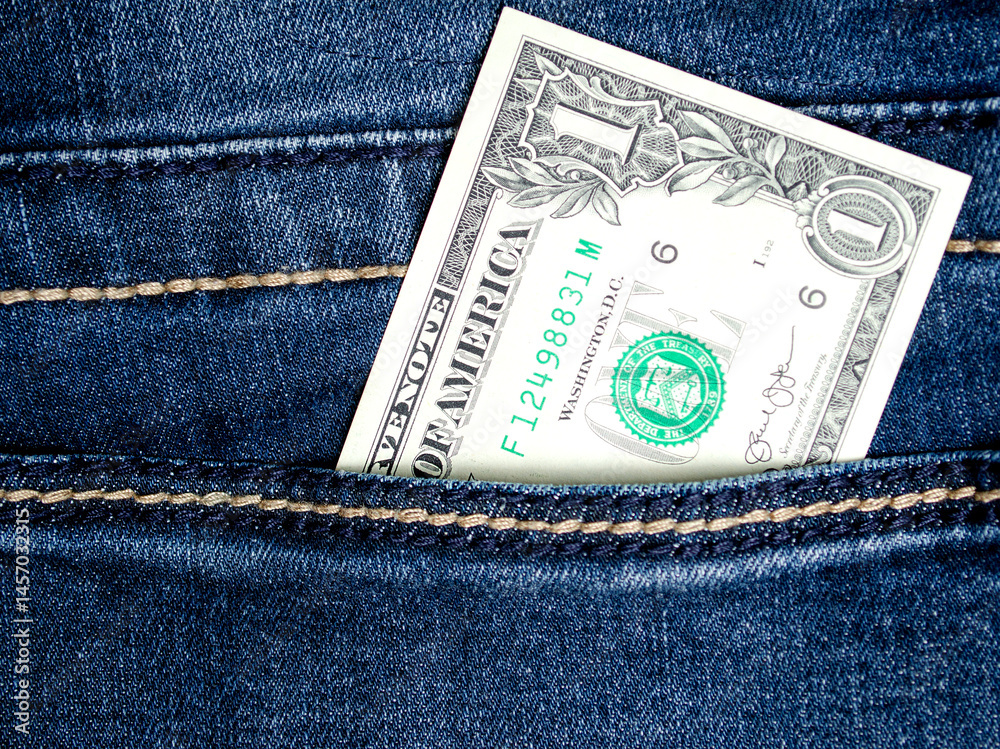 1 dollar lies in the pocket of blue jeans close-up