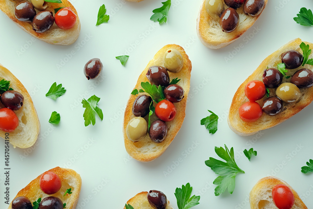 Bruschetta Topped With Colorful Olives and Fresh Herbs on a White Surface