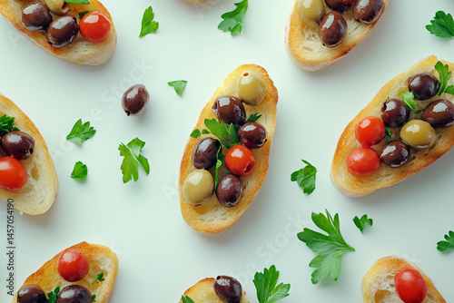 Obraz na płótnie Bruschetta Topped With Colorful Olives and Fresh Herbs on a White Surface w salonie