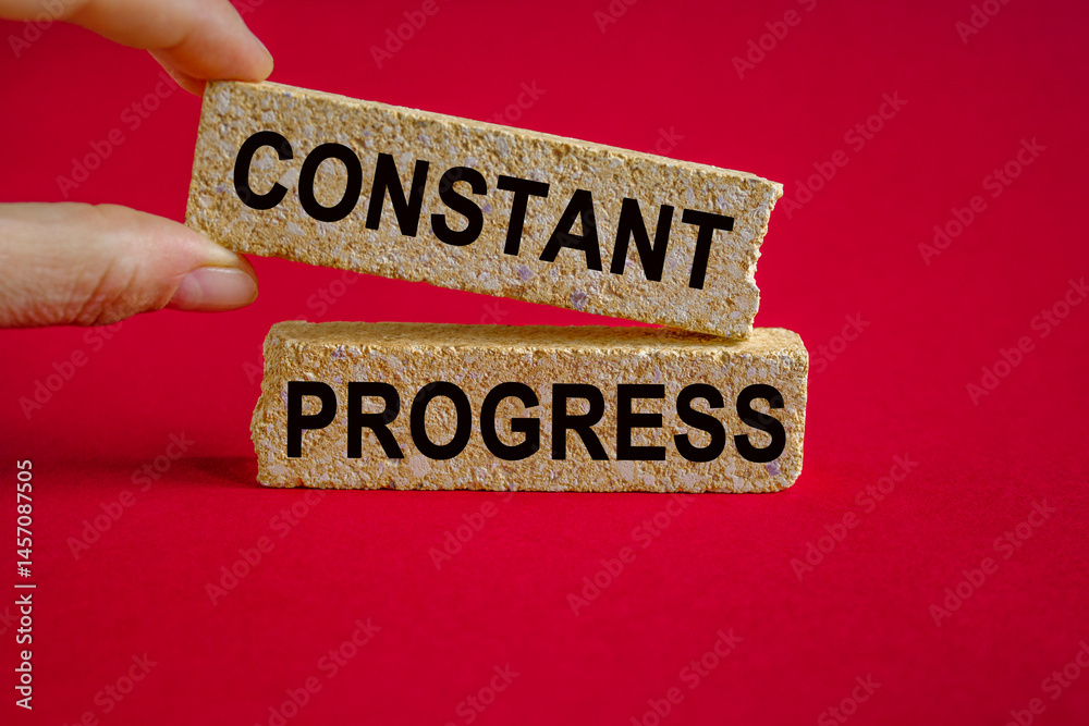 Constant Progress symbol. Concept words Constant Progress on brick blocks. Businessman hand. Beautiful red background. Business and Constant Progress concept.