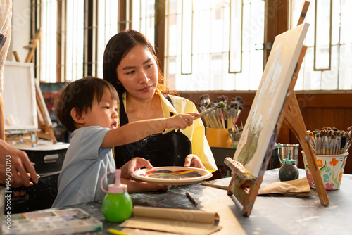 Valokuva Parents supervise young children while drawing at a studio