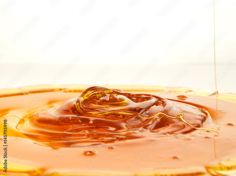 Pouring golden honey on a white background