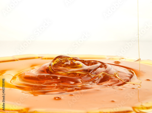 Obraz na płótnie Pouring golden honey on a white background w salonie