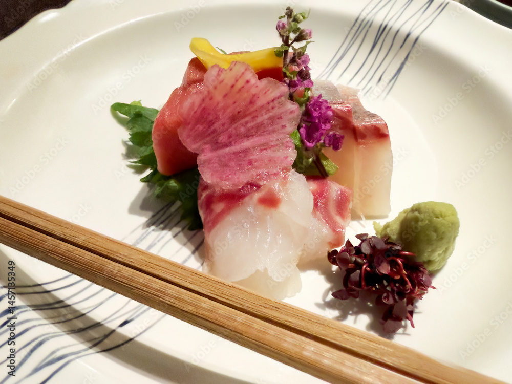 Raw seafood fish or Japanese sashimi with fine garnishes on white plate