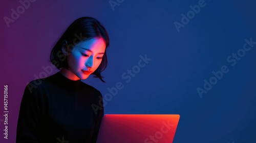 Woman working on laptop, red and blue neon light portrait, studio shot