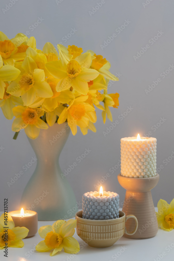 yellow daffodils with candles in white interior