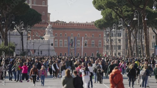 Busy pedestrian street Via dei Fori Imperiali in Rome, blurred view on crowd of unrecognizable walking business and tourist people.