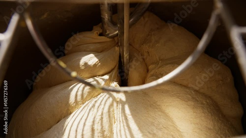 Professional bakery dough mixing detailed close-up of the kneading process in an industrial mixer, essential for fresh bread and baked goods. High quality 4k footage
