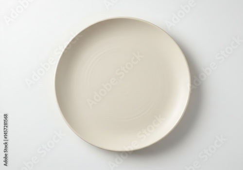 A simple minimalistic cream colored round plate on a white background in a centered composition