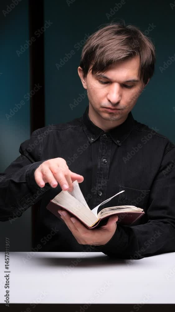 vertical video Priest reading holy book at desk in dark room vertical video Priest reading holy book at desk in dark room