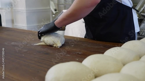 Professional baker preparing bread mixing, kneading, and shaping dough by hand in a bakery, traditional baking process for fresh artisan loaves and pastries. High quality 4k footage