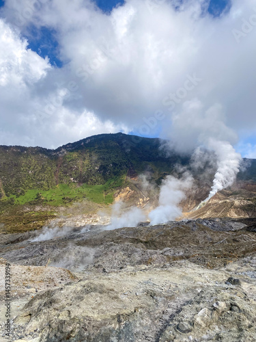 Beautiful view of the volcanic crater area on sunny day with blue sky and cloud. Structure of crater layer with steam gas fomarol. Papandayan mount,Indonesia