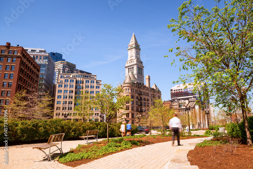 Obraz na plátně Boston’s vibrant cityscape, blending historic and modern architecture with a bustling downtown, budding trees, and pedestrians in motion, encapsulating the energy of urban life in spring