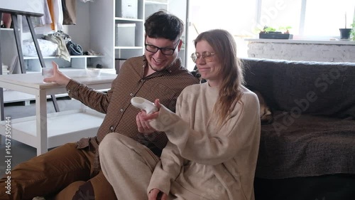 couple playing video games using controller at home, having fun