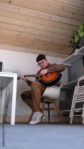 Young man musician learning to play classical guitar at home