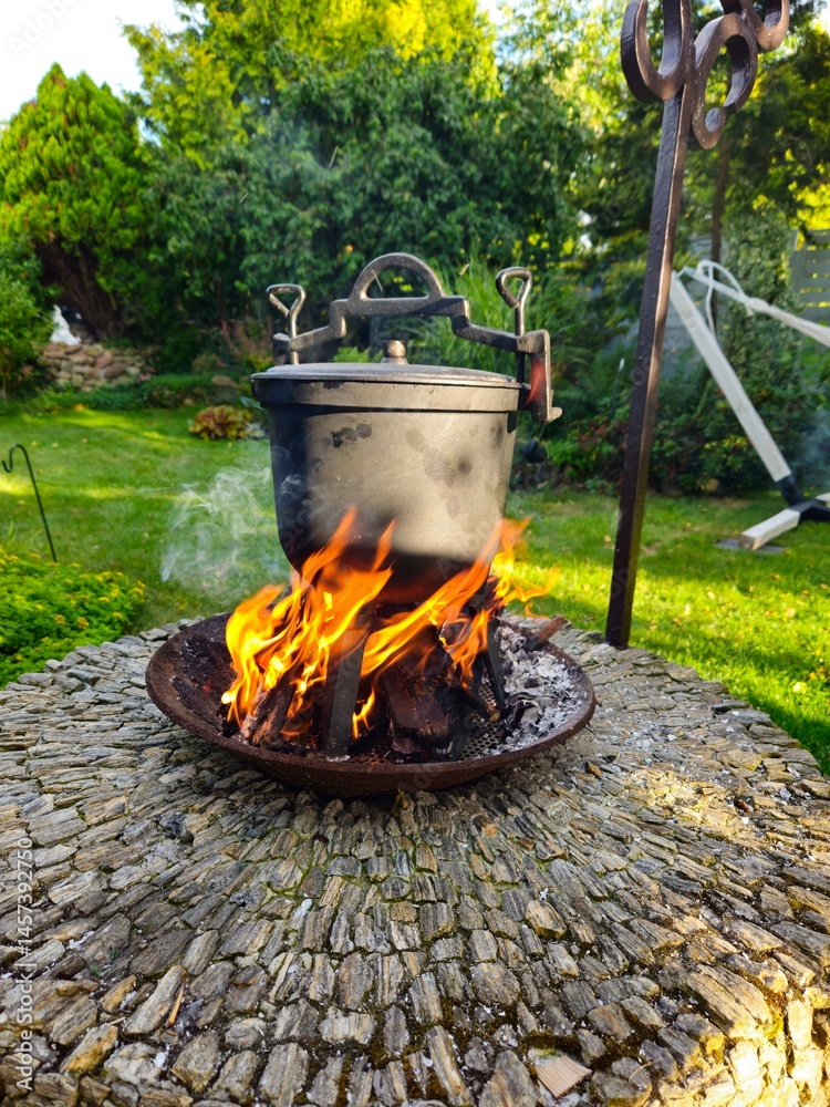 Fototapeta premium kociołek żeliwny, myśliwski, na ognisku podczas przygotowania potrawy