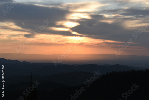 sunset in the black forest mountains under cloudy skies