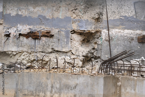Urban decay and exposed rebar in crumbling concrete wall for construction background