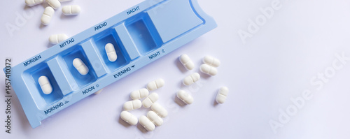 Banner. Plastic pill organizer with tablets sorted by time of day - morning, afternoon, and evening. A concept of proper medication intake, home treatment, and dosage control