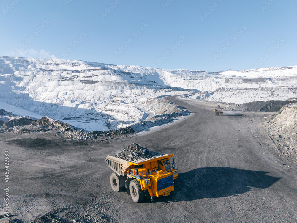 Banner Open pit coal mine in winter landscape with mining trucks, view by drone