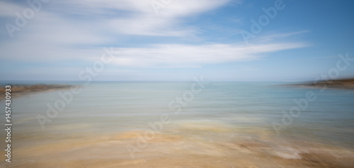 Obraz na płótnie Blurred ocean horizon with dynamic sky movement w salonie