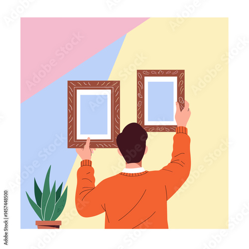 Framing Perfection: A person meticulously hangs two elegant frames on a vibrant, colorful wall, adding a touch of artistic flair and personality to the space, symbolizing home decor.