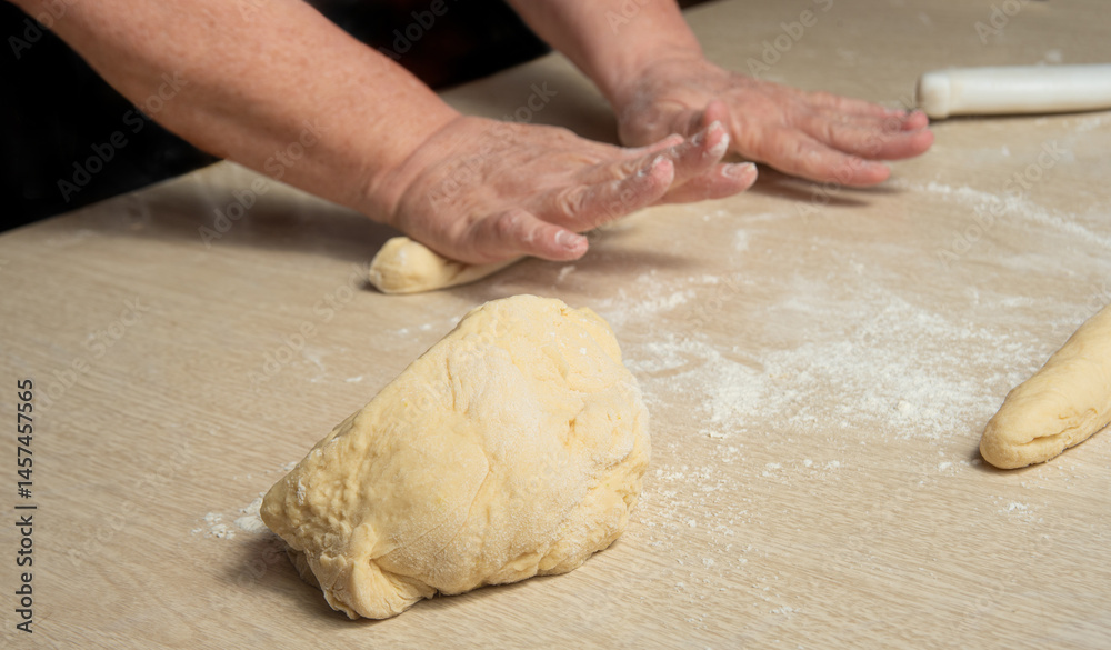 Raw homemade bread, preparing and kneading the bread before baking, on a wooden surface, selective focus. Raw homemade bread, preparing and kneading the bread before baking, on a wooden surface, selective focus.