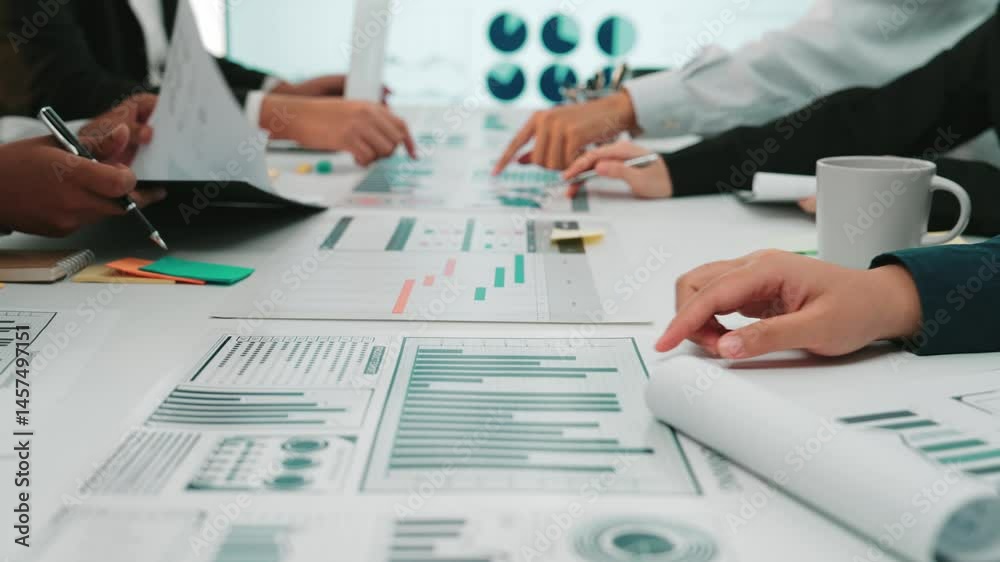 A diverse business team engages in collaborative financial analysis, utilizing charts and graphs in a modern office. The focus is on technology and strategic planning. SACTR