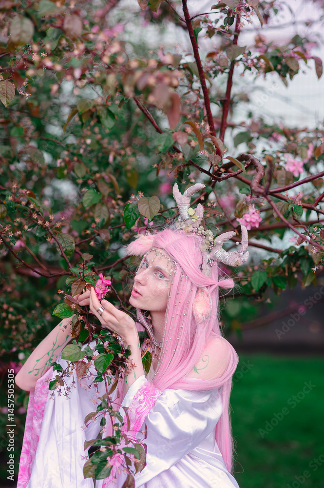 Obraz premium Deer dryad girl against the background of a blooming pink apple tree